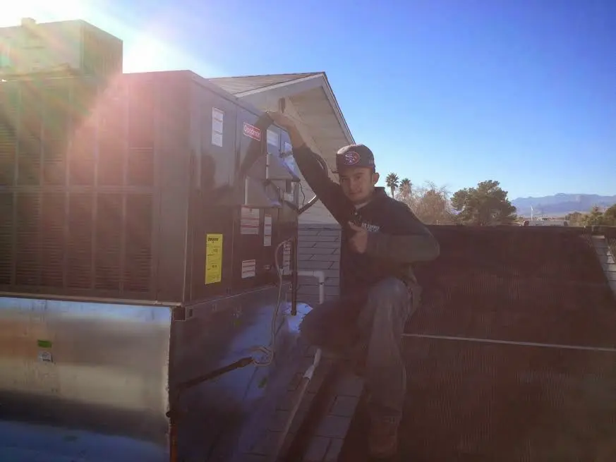 HVAC technician performing HVAC Inspection on a rooftop unit in Bloomington